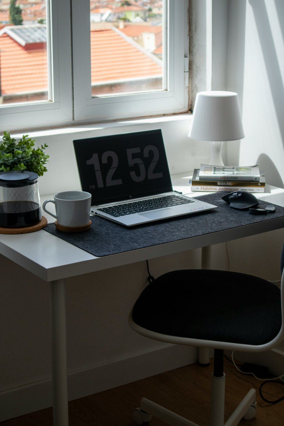 Moderner Schreibtisch im Homeoffice mit Laptop, Tasse und Pflanze.